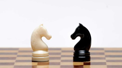 Black and white chess pieces opposing each other
