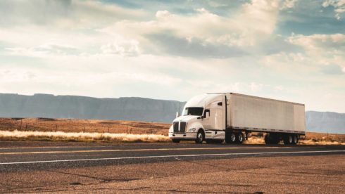 truck on the open road with mountains in the background